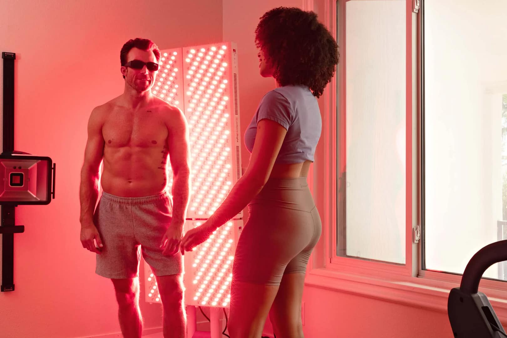 A man and woman talking in a room lit by a MitoPRO 1500+ Mito red light panel
