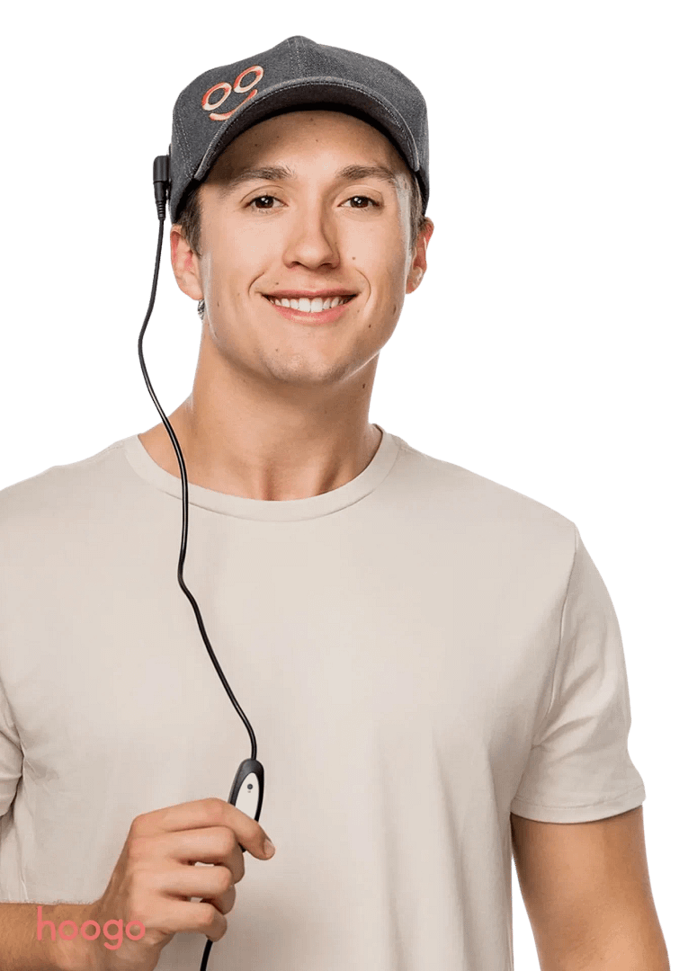 Uomo multitasking mentre usa Cappello Terapia Luce Rossa Hooga con controller per regolazioni facili