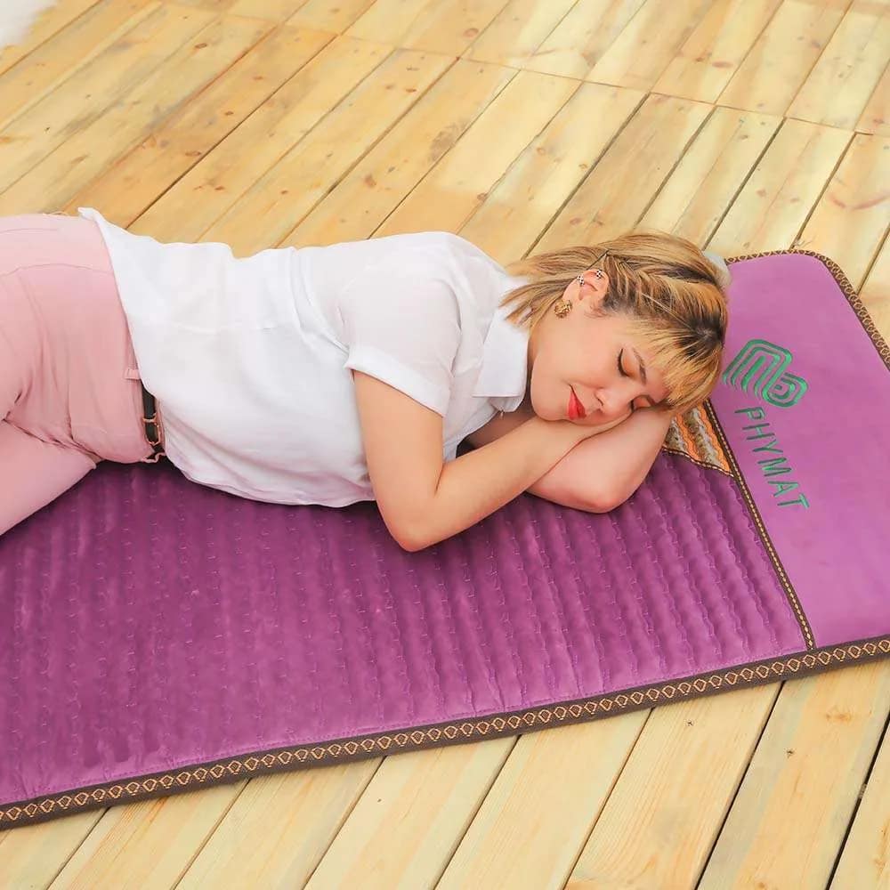 Woman sleeping comfortably on Phymat Amethyst PEMF Mat with infrared and PEMF therapy
