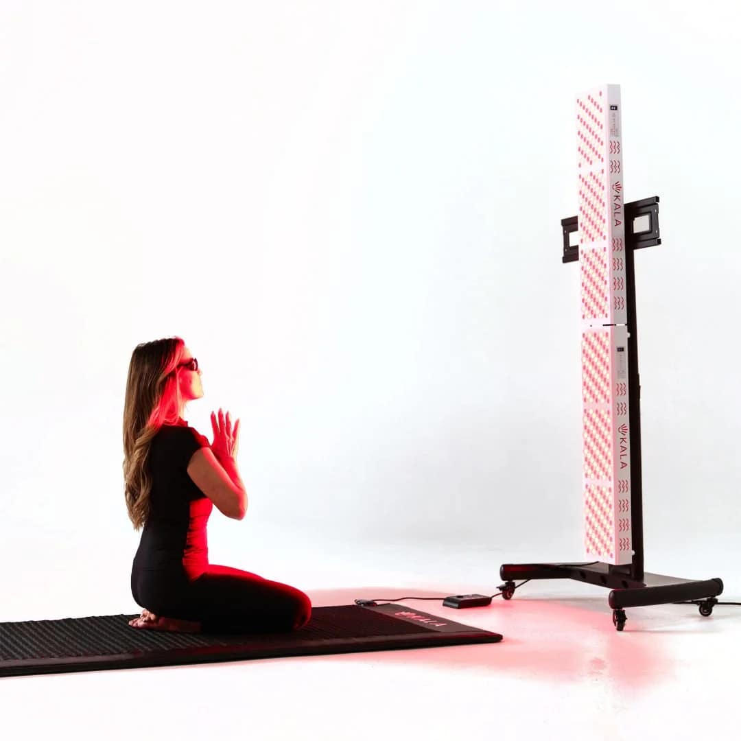 Woman meditating during red light therapy session with Kala Elite DUO on vertical stand