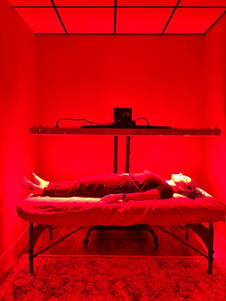 Woman getting infrared light therapy under Kala Elite DUO on horizontal stand