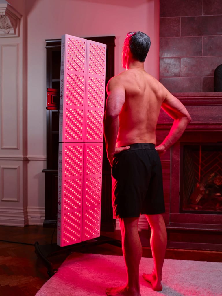 Man receiving full-body photobiomodulation treatment with Kala Elite QUAD panel