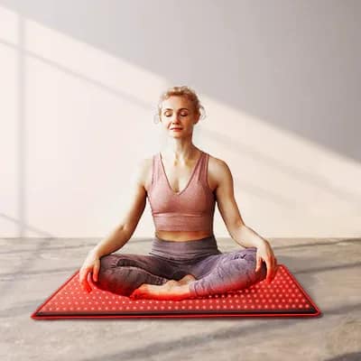 Woman meditating on BestQool LED Mat for combined mindfulness and red light therapy practice