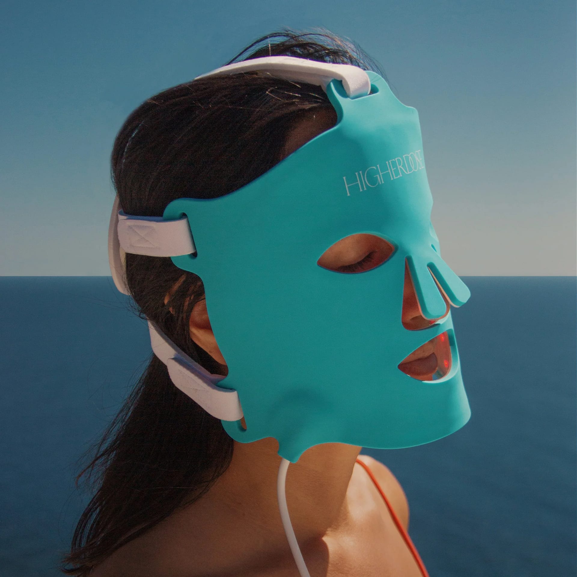 Routine benessere in spiaggia usando Maschera Viso HigherDose per Terapia Luminosa per cura di sé