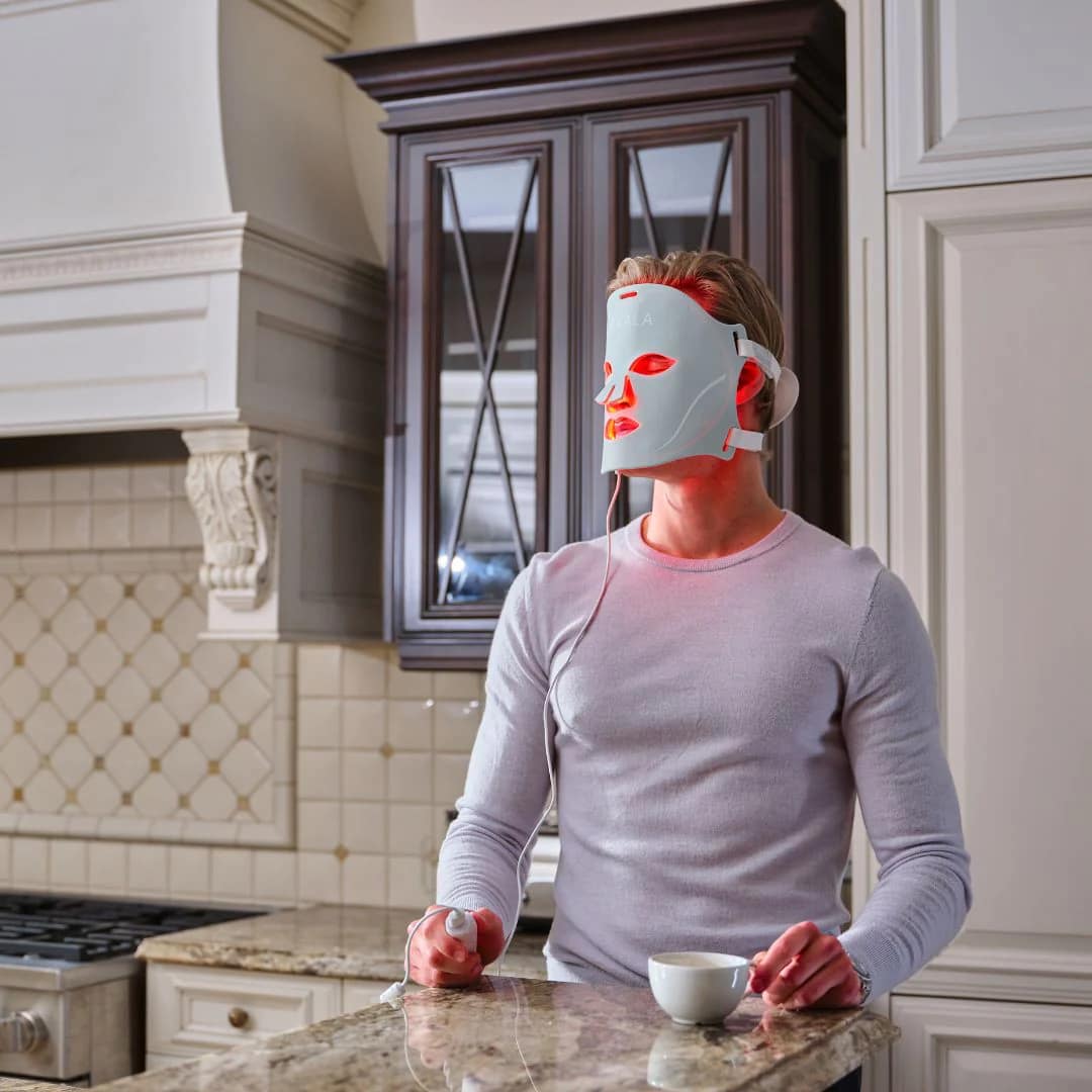 Uomo che indossa Maschera Viso Kala mentre fa multitasking durante sessione terapia LED