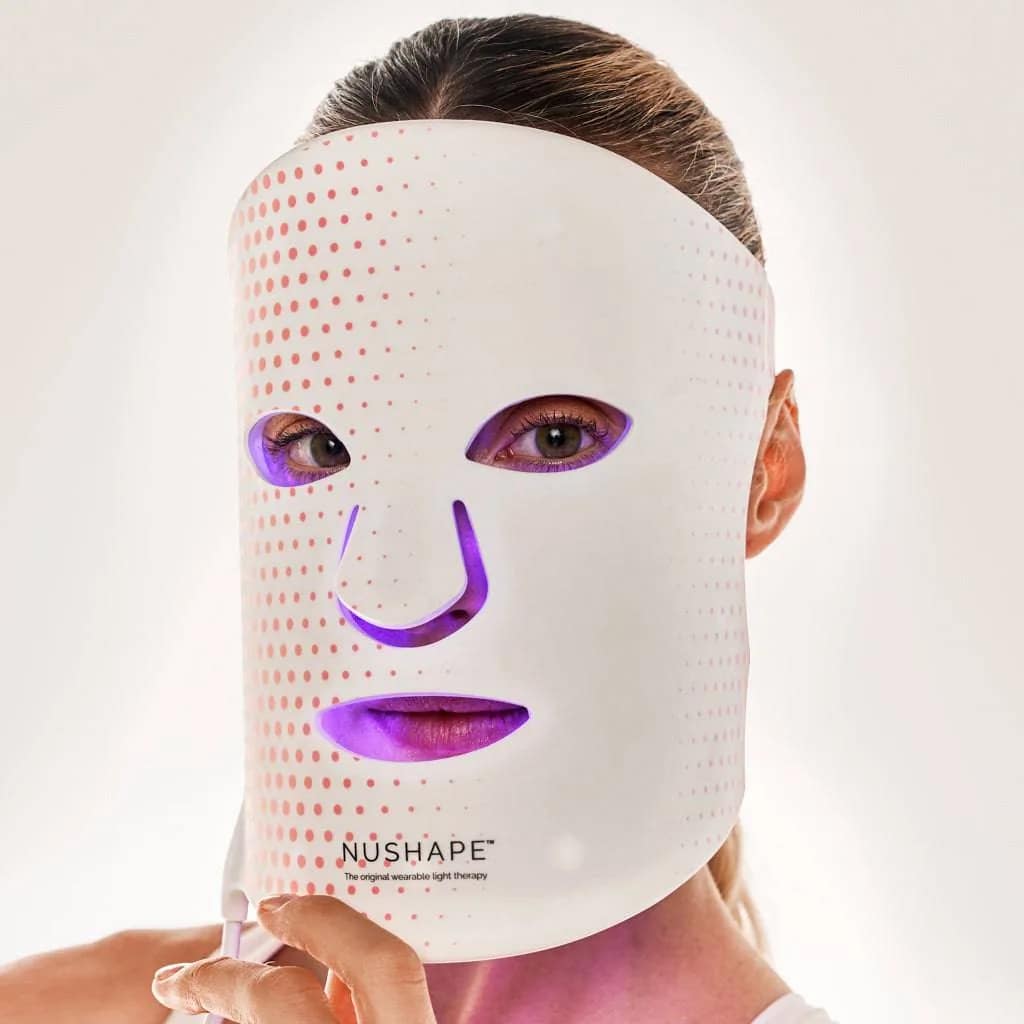 Donna che usa Maschera Viso Nushape con terapia LED rossa e blu simultanea per trattamento combinato