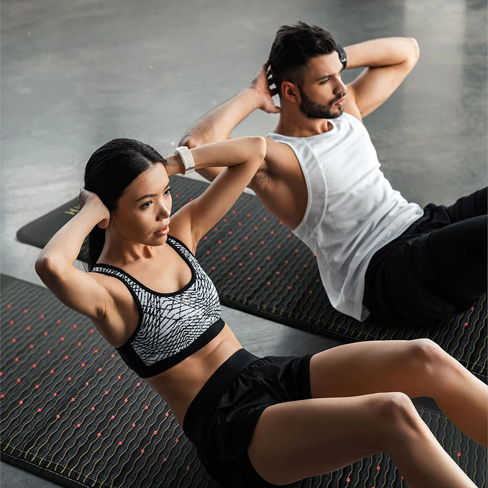 Couple engaging in abdominal workouts on HealthyLine JET PEMF Mat