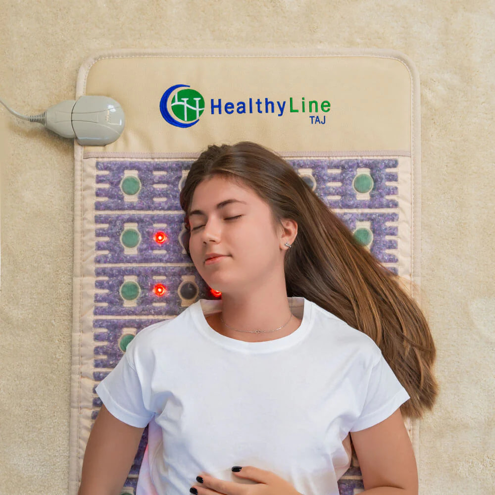 Woman's face showing relaxation while lying on HealthyLine TAJ PEMF Mat during therapy session