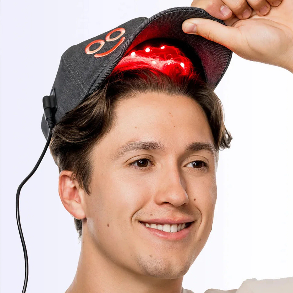 Primo piano uomo che indossa Cappello Terapeutico LED Hooga durante sessione trattamento crescita capelli mani libere