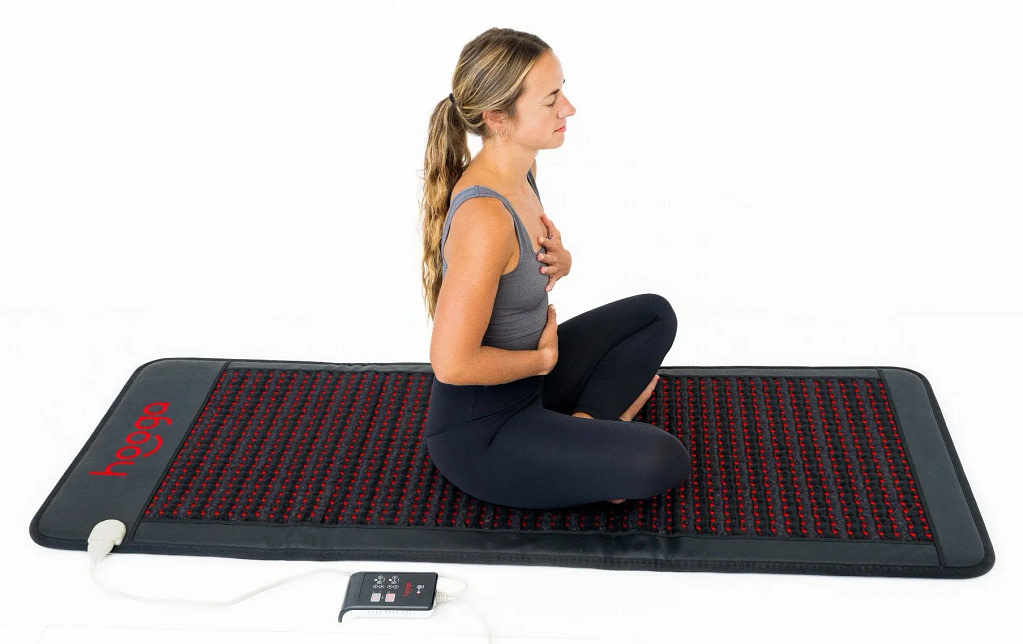 Woman using Hooga PEMF Mat for relaxation and muscle recovery during yoga