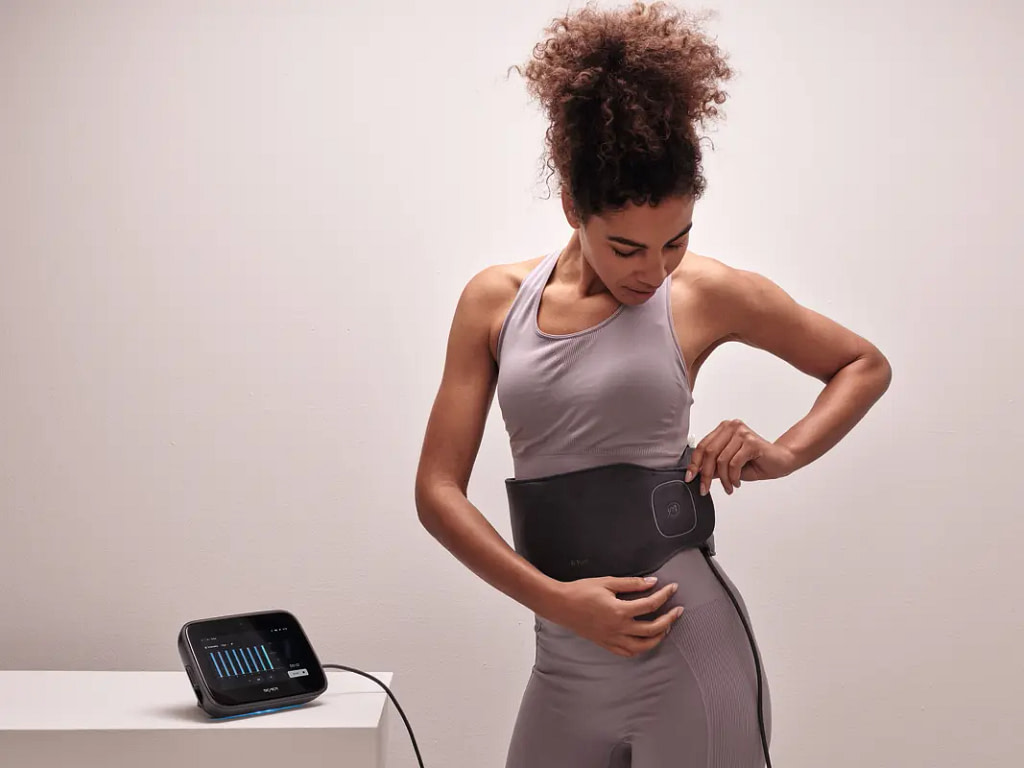 Woman securing the Bemer EVO Pad around her hips