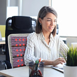 Professional using HealthyLine Platinum Chair PEMF Mat at desk for enhanced comfort and circulation