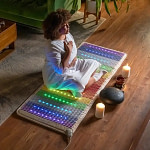 Woman meditating on the Rainbow Chakra mat