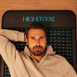 Man relaxing on Higherdose infrared PEMF mat during recovery session