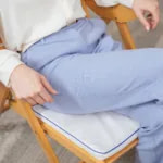 Woman seated on NeoRhythm pad to relieve back tension