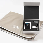 Open NeoSurround mat PEMF system box showing the room device, test tube, and charger