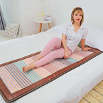 Relaxed woman using Phymat Gesmtones PEMF mat for wellness and energy flow