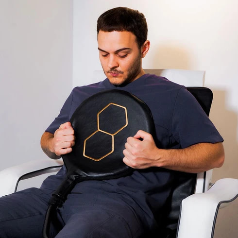 Man holding the Celler8 MAX pad applicator against his chest