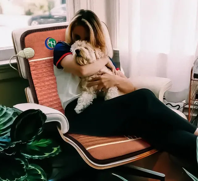 Young woman and dog resting on lounge chair with HealthyLine TAO PEMF Chair Mat for cozy relaxation