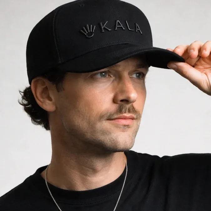 Man adjusting Kala LED Therapy Hat for comfortable fit during simple cordless hair growth session