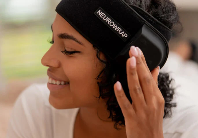 User operating Nushape Neurowrap Pulse Pro controller while wearing device