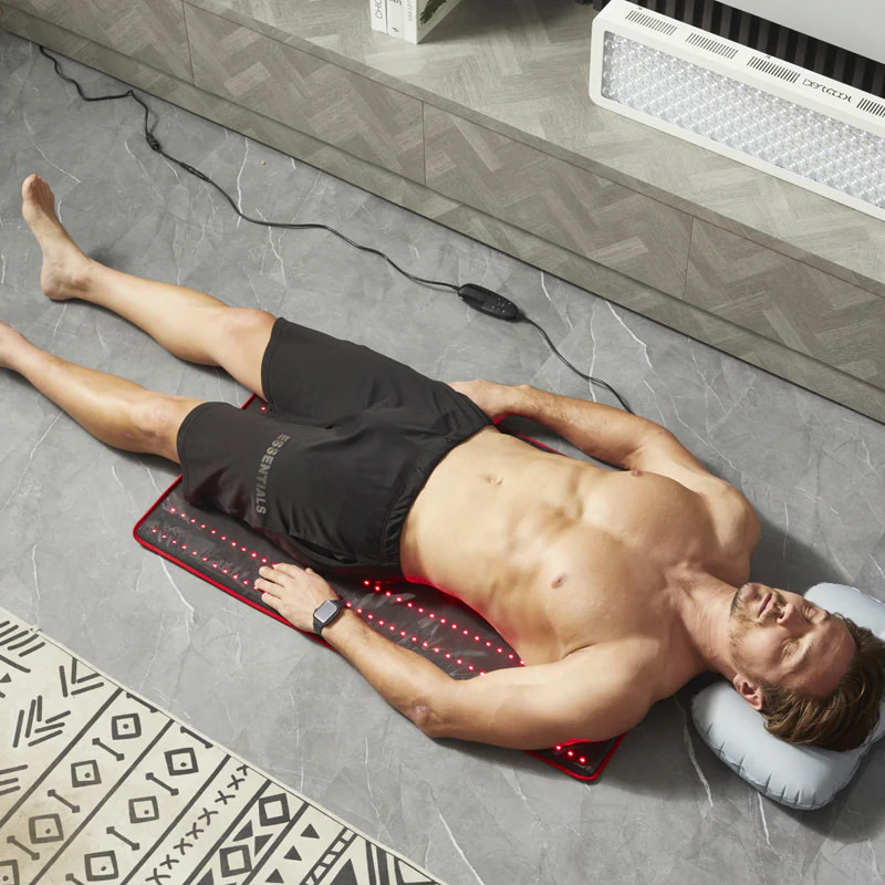 Man using BestQool LED Mat with included inflatable pillow for enhanced comfort during therapy