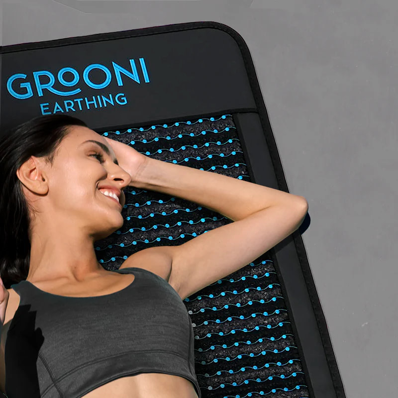 Woman enjoying relaxation on Grooni PEMF mat with infrared therapy