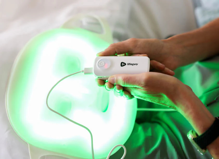LifePro LED Face Mask activated in green light mode for hyperpigmentation treatment