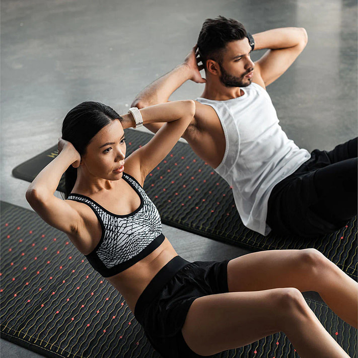 Couple engaging in abdominal workouts on HealthyLine JET PEMF Mat