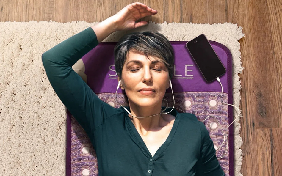Focused view of woman resting on the Sparkle PEMF mat during PEMF therapy