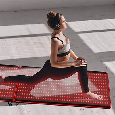 Woman practicing yoga on expanded BestQool Red Light Mat system with dual connected panels