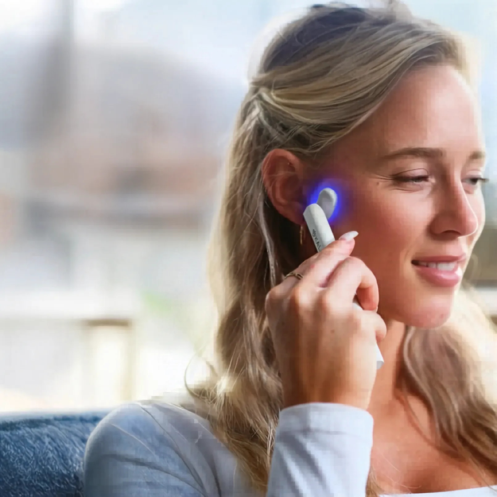 Woman using Kala Wand in blue light mode for acne treatment and targeted skin clarifying therapy