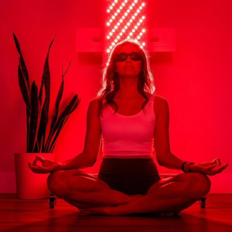 Woman meditating on the floor with her back to the MitoPRO 1500+ mito panel