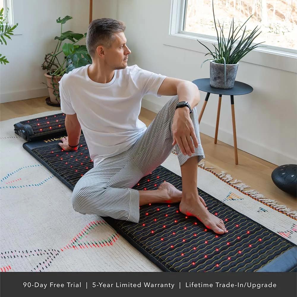 Individual seated on HealthyLine JET PEMF Mat engaging in relaxation therapy