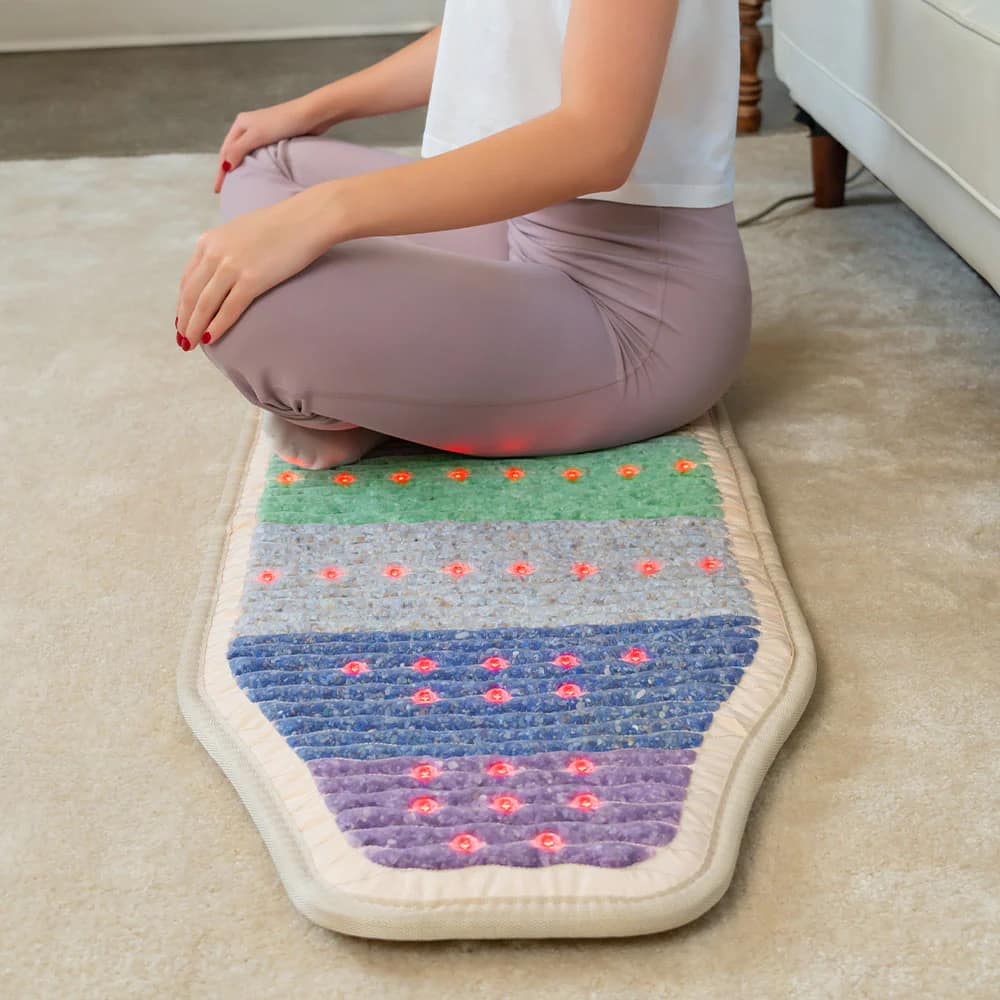 Woman meditating deeply on HealthyLine Rainbow Chakra PEMF Chair Mat for energy alignment