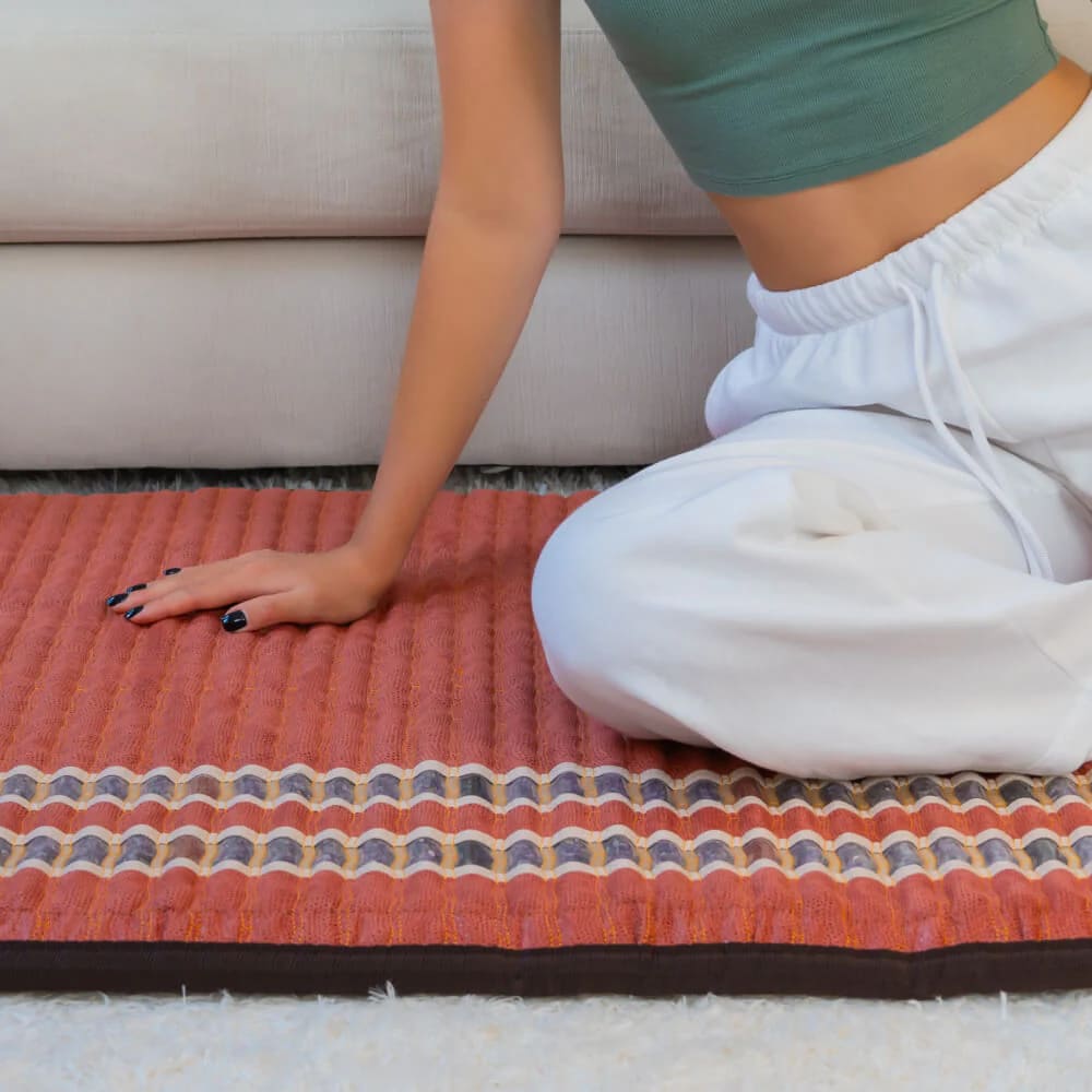 Relaxed woman using the TAO PEMF Mat for back pain relief and circulation boost