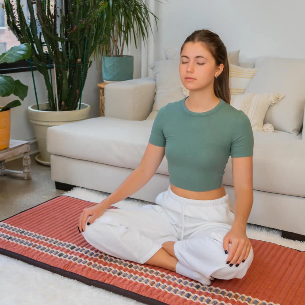 Meditation on PEMF infrared mat with natural stones and far infrared heat therapy