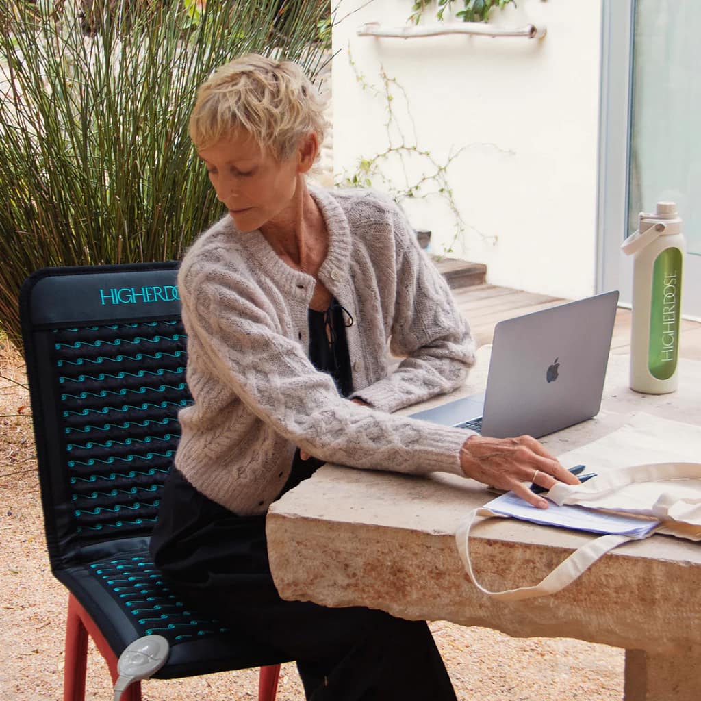 Infrared PEMF mat benefits professional woman using laptop chair therapy session"
