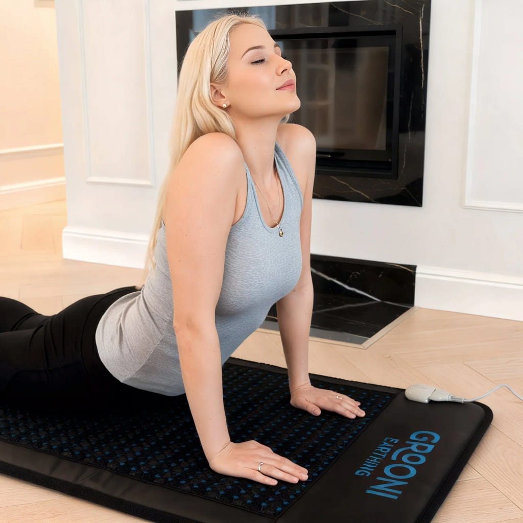 Practicing yoga on Grooni PEMF mat for enhanced flexibility and recovery