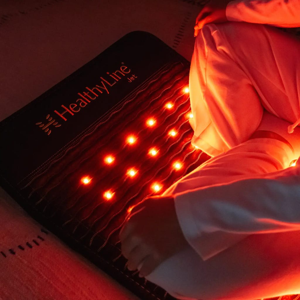 Man using HealthyLine JET PEMF MiniMat with glowing red light LEDs for enhanced therapy