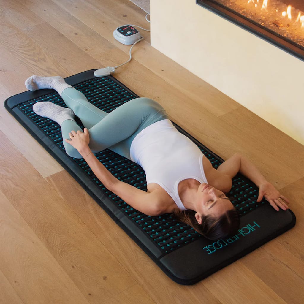 Woman practicing yoga on Higherdose PEMF mat for flexibility and stress relief