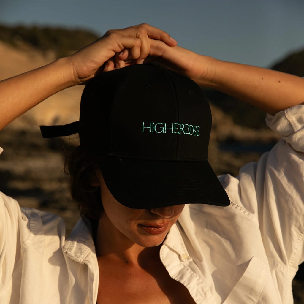 Woman using HigherDose Red Light Therapy Hat outdoors demonstrating wireless portability and freedom