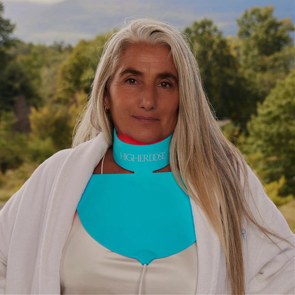 Outdoor lifestyle shot featuring HigherDose LED Neck Device for flexible hands-free wellness therapy