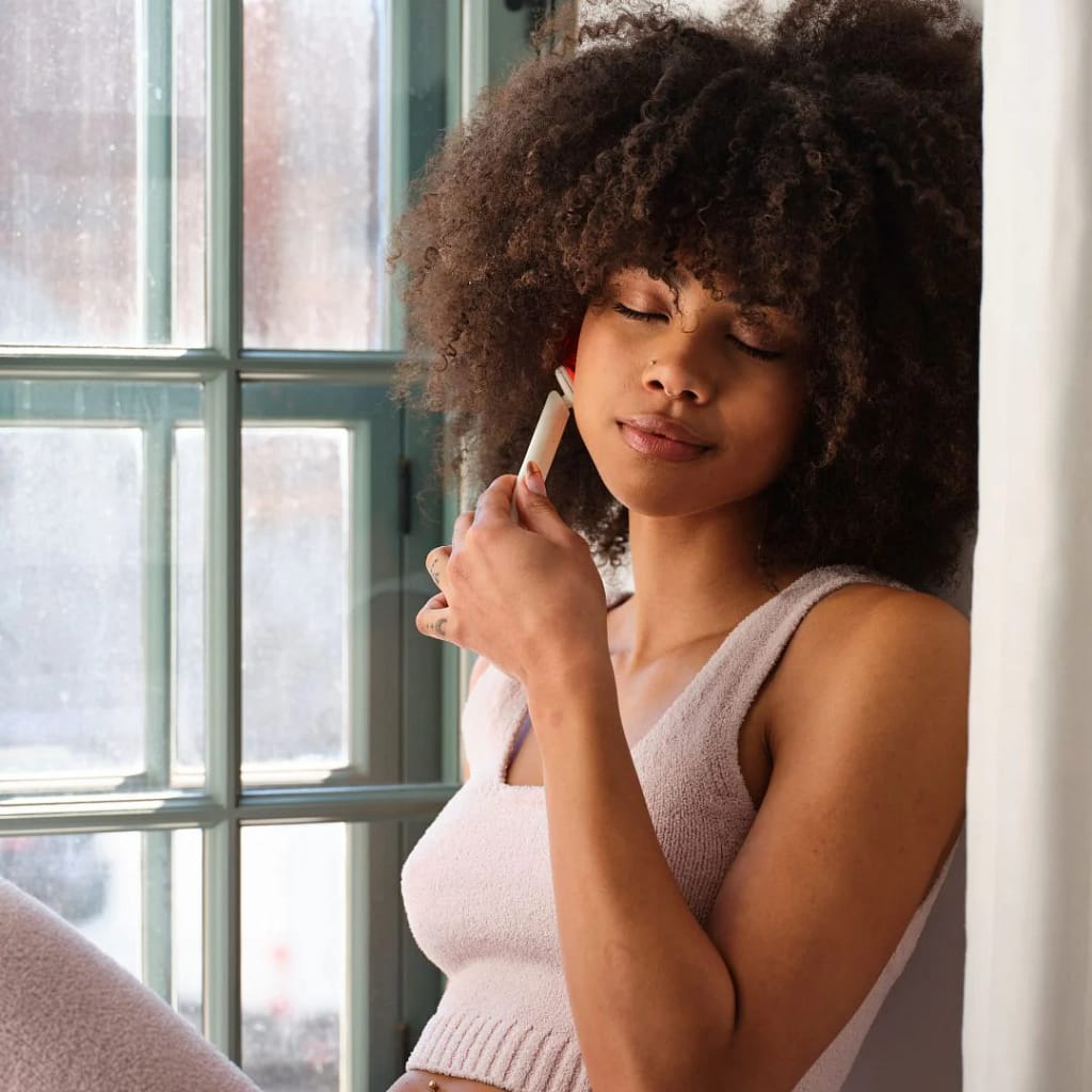 Woman using Kala Red Light Therapy Wand on face for targeted at-home LED anti-aging treatment session