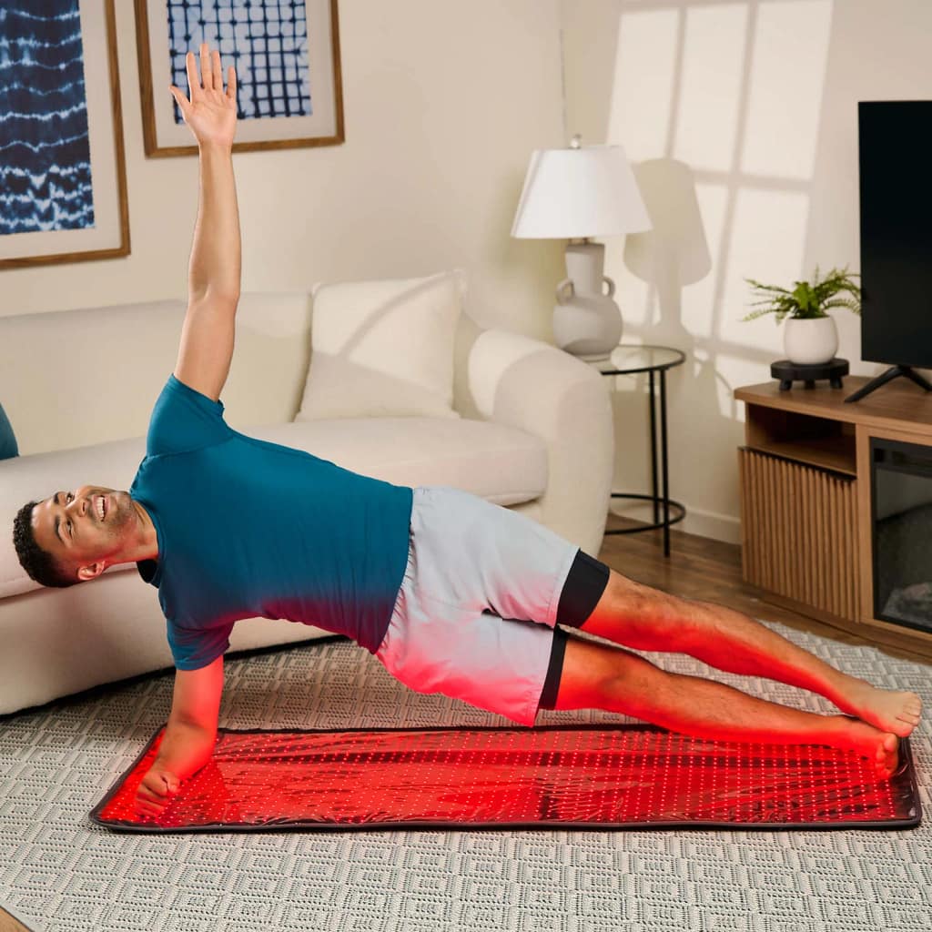 Man practicing yoga on LifePro AllevaBody Mat combining exercise with full-body red light therapy treatment