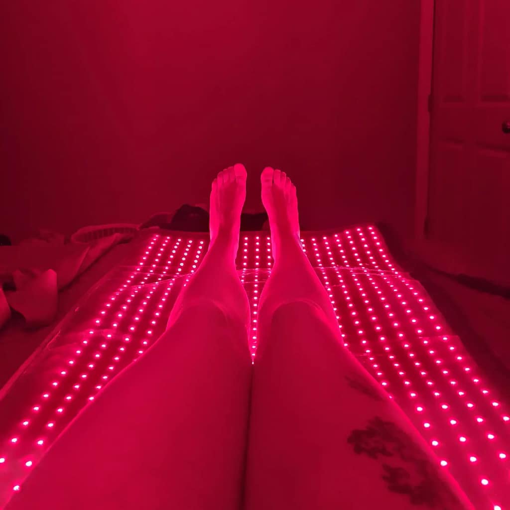 Woman's legs on LifePro LED Mat showing targeted lower body red light therapy application