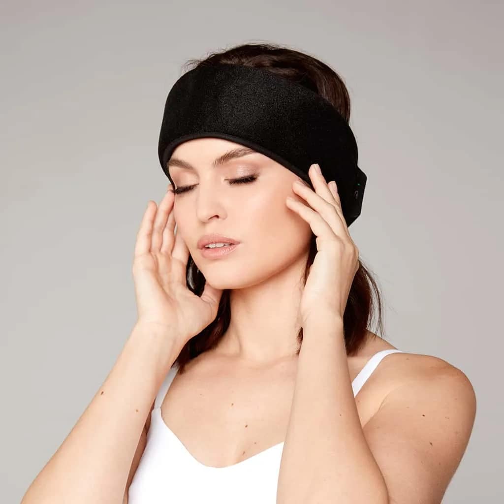 Young woman using Nushape Neurowrap Pulse Pro headband dual therapy