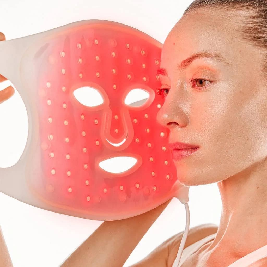 Applying Nushape Red Light Therapy Mask to face during anti-aging skincare session