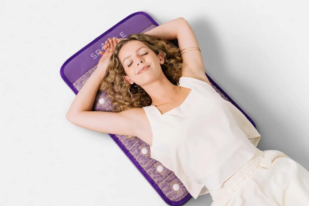 Woman enjoying relaxation session on Sparkle PEMF MiniMat for stress relief and better sleep