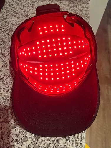 Interior view of HigherDose LED Hat displaying activated wireless red light array for scalp therapy